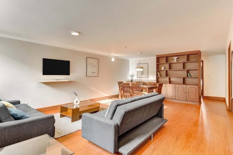 Bright and welcoming living area featuring comfortable seating, warm wood floors, and an open layout perfect for relaxing after a day in the city.