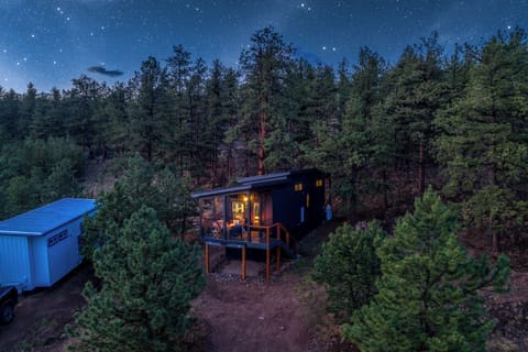 Watch the cabin glow like a lantern in the pines as the stars come out above the ridge.
