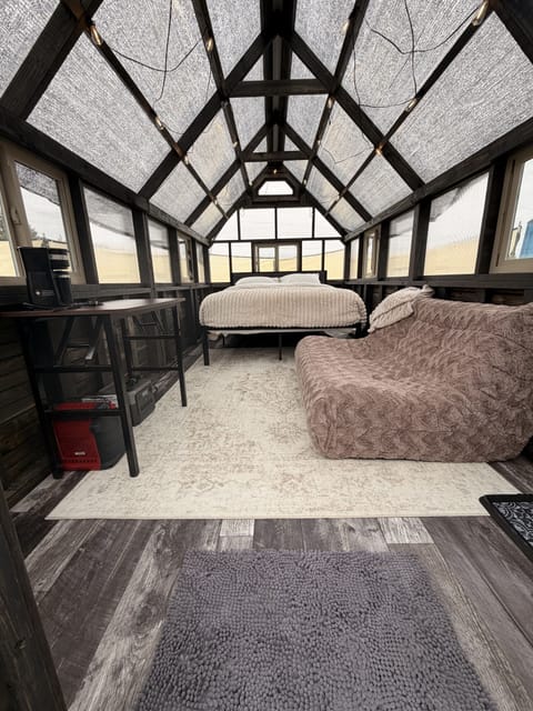 Bright loft retreat with skylit ceiling, cozy lounge sofa, and workspace