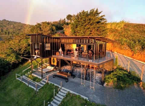 The house features an L-shaped balcony that fully integrates with the interior. 