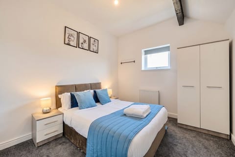 Calm second bedroom with crisp linens and fresh towels ready for guests