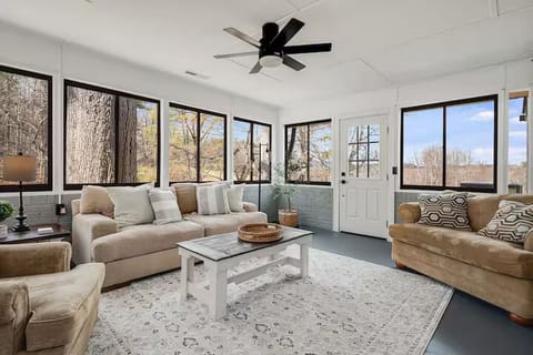 Unwind in this sun-filled lounge with wall-to-wall windows 🌞, cozy seating 🛋️, and peaceful nature views 🌳. Featuring a ceiling fan, soft décor, and plenty of light, it’s the perfect spot to relax, read, or enjoy your morning coffee ☕✨