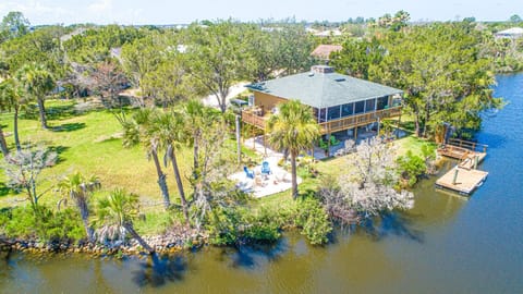 Exterior of home with water views, fire pit, water views, & dock