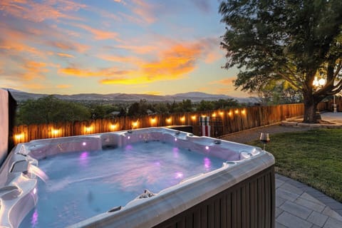 Soak in the hot tub under colorful sunset skies