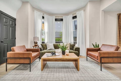 Bright living room w/ cozy wicker armchairs, a wood coffee table & a soft area rug to sink into.