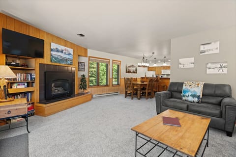 Relax in your spacious living room with a cozy fireplace, comfortable seating, and plenty of natural light. The open layout flows seamlessly into the dining and kitchen areas, perfect for gathering together.
