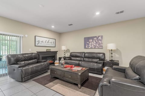 Relax in this modern living room with leather seating and an electric fireplace.