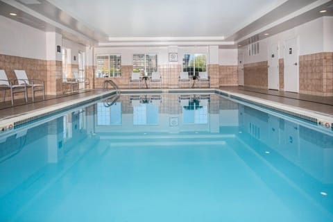 Indoor heated swimming pool with lane markers and surrounding pool deck.
