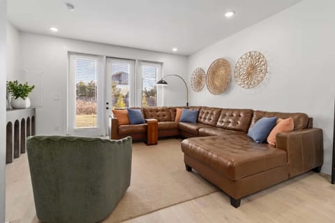 Living area with stylish leather couch and seating for TV viewing + sleeper sofa and patio access (sleeps 2)