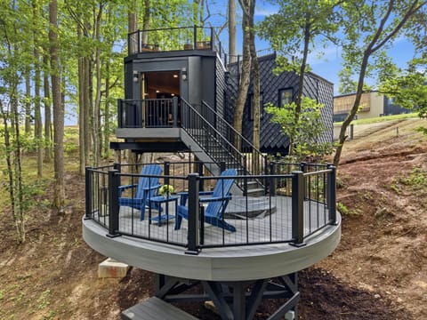 Perched among the treetops, this modern cabin invites you to unwind by the crackling fire pit deck or soak in sweeping views from the private rooftop terrace — the perfect blend of sleek design and mountain serenity, day or night.