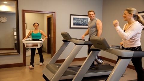 Well-equipped fitness center with cardio machines, free weights, and flat-screen TV.