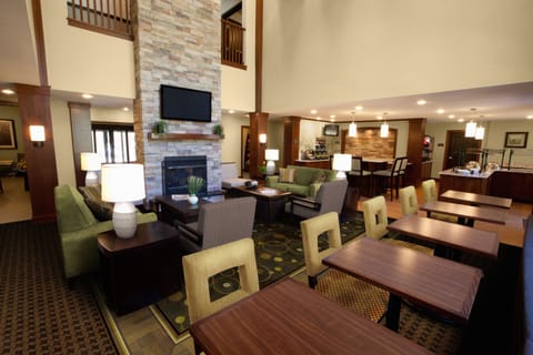 Spacious lobby featuring a stone fireplace, comfortable seating, and adjacent breakfast area.