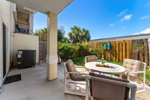 Outdoor patio with dining seating and fenced-in backyard.
