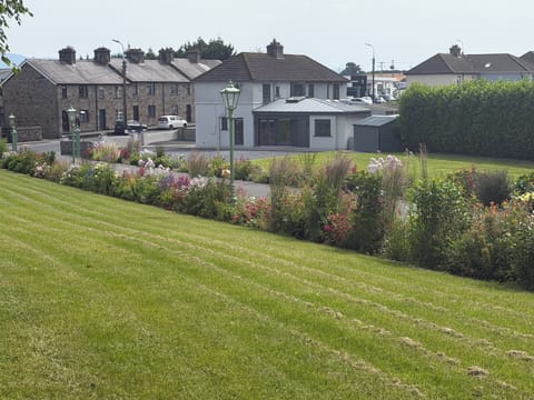 A view of the Carrigeen Castle gardens and woodland adjacent to No. 1 Bella Vista @ Carrigeen Castle, showing its entrance, garden and parking facilities. 
The heritage streetscape is accentuated by the sandstone-built Mill Villas and Mill Cottages (1910) opposite.