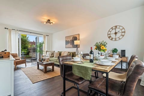 Relax in the spacious living room with a sunny garden view. The open space features plenty of seating, access to the garden and a SMART TV.