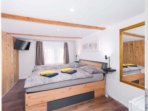 Bright private double room with a comfortable bed, window, fresh towels, and simple practical furnishings.
