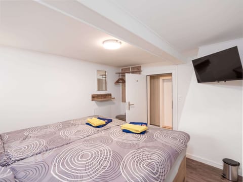 Private double room with TV, double bed, fresh towels, and access to shared bathroom facilities.
