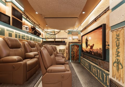 Experience ultimate comfort in our private home theater with plush brown leather recliners, vibrant wall art, and ornate decor. Enjoy stylish movie nights in a cozy ambiance designed for unforgettable cinematic moments.