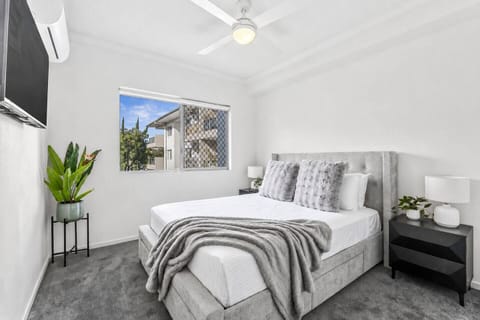 Unwind in the bedroom with a queen bed, private TV and calming neutral tones, creating a comfortable retreat after a day out.