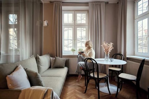 Jasny salon stanowi serce apartamentu. Wyposażony został w wygodną, rozkładaną sofę z funkcją spania, która zapewnia dodatkowe miejsce noclegowe, oraz telewizor.