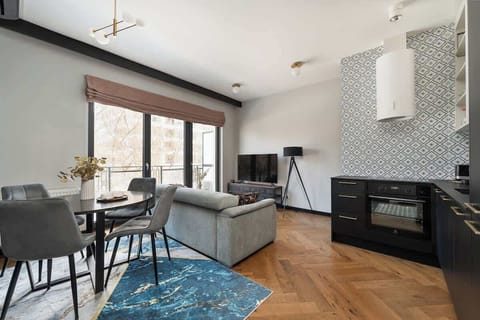 Salon stanowi serce apartamentu i został wyposażony w wygodną, nierozkładaną sofę, która zapewnia komfortowy wypoczynek w ciągu dnia. Naprzeciwko znajduje się telewizor z funkcją Smart TV, idealny na wieczorny relaks.