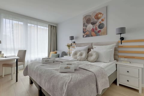 Chlebova 2.06 to jasny i funkcjonalny apartament dla 5 osób, w tym maksymalnie 4 dorosłych. Oferuje sypialnię, salon z aneksem kuchennym i jadalnią, łazienkę z prysznicem i pralką oraz balkon z widokiem na rzekę.