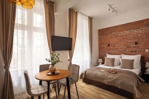 Centralnym elementem studio jest wygodne łóżko małżeńskie, ustawione naprzeciwko telewizora z telewizją naziemną oraz Smart TV, idealnego na wieczorny relaks. Naprzeciwko znajduje się rozkładana sofa.