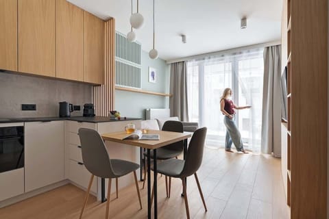 Przestronny salon stanowi serce apartamentu. Wyposażony jest w wygodną, rozkładaną sofę, która zapewnia dodatkowe miejsce do spania. Naprzeciwko znajduje się telewizor z funkcją Smart TV.