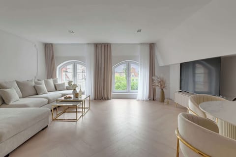 Na pierwszym poziomie znajduje się przestronny salon z wygodną, rozkładaną sofą z funkcją spania, która zapewnia dodatkowe miejsca noclegowe.