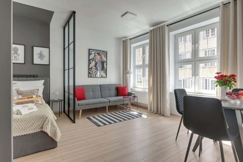 Stylowe i przestronne wnętrze łączy nowoczesny design z komfortem wypoczynku. Jasna część dzienna z wygodnym łóżkiem, sofą i strefą jadalnianą tworzy idealne miejsce na relaks po dniu spędzonym na odkrywaniu uroków Gdańska.