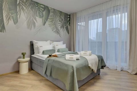 Nowoczesne studio wyposażone w komfortowe łóżko małżeńskie, naprzeciw którego znajduje się telewizor z kanałami kablowymi i funkcją SMART TV. To idealne miejsce do wypoczynku po dniu spędzonym w mieście.