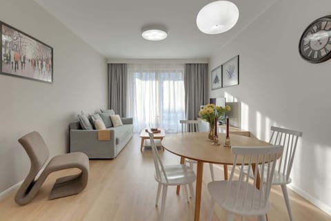 Salon stanowi centralną część apartamentu i został zaprojektowany z myślą o relaksie. Znajduje się tu wygodna rozkładana sofa, ustawiona naprzeciw telewizora z dostępem do kanałów naziemnych oraz funkcją Smart TV. 