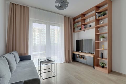 Przestronny salon oferuje rozkładaną sofę, telewizor Smart TV oraz jasne, dobrze doświetlone wnętrze sprzyjające wypoczynkowi.