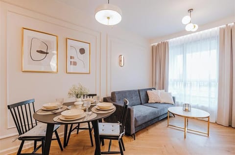 Salon to idealna strefa wypoczynku, urządzona w nowoczesnym stylu z przytulnymi akcentami. Znajduje się tu rozkładana sofa, która zapewnia wygodne miejsce do relaksu w ciągu dnia i dodatkową przestrzeń do spania. 