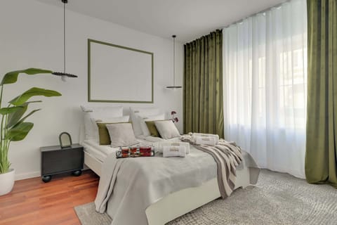 W części wypoczynkowej znajduje się wygodne łóżko dwuosobowe oraz rozkładana sofa, dzięki czemu apartament może komfortowo ugościć do czterech osób. To idealne miejsce do odpoczynku po dniu spędzonym na zwiedzaniu miasta.