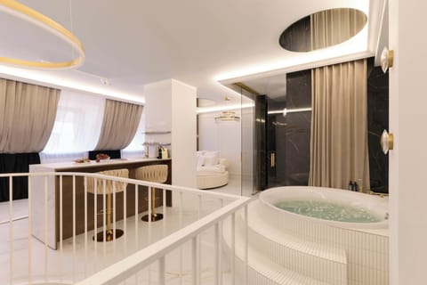 Najbardziej wyjątkowym elementem apartamentu jest prywatna strefa wellness z dużą wanną z funkcją hydromasażu/jacuzzi, umieszczoną na podwyższeniu i stanowiącą centralny punkt wnętrza.