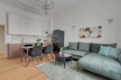 Salon stanowi przytulne centrum apartamentu. Znajduje się tu duża, rozkładana sofa, która może służyć jako dodatkowe miejsce do spania, stolik kawowy oraz telewizor z kanałami TV i funkcją Smart TV.