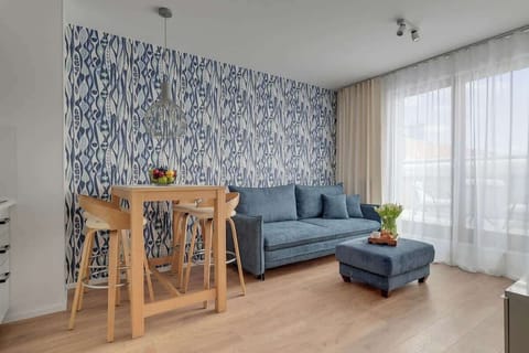 Klimatyzowany salon stanowi komfortową przestrzeń do relaksu. Znajduje się tu wygodna, rozkładana sofa, ustawiona naprzeciw pufy oraz telewizora z dostępem do kanałów TV i funkcją Smart TV.