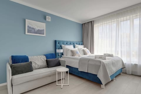 W części sypialnianej znajduje się łóżko małżeńskie, rozkładana sofa, telewizor Smart TV, biurko do pracy oraz pojemna szafa.