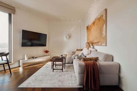 Słoneczny, przestronny salon stanowi serce apartamentu. Znajduje się tu duża, bardzo wygodna sofa, idealna do wypoczynku, a naprzeciwko - telewizor z funkcją SMART TV, który umili wieczory po dniu pełnym wrażeń.