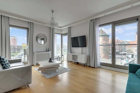 Przestronny salon stanowi wygodną strefę wypoczynku z dwiema komfortowymi sofami, w tym jedną rozkładaną, która zapewnia dodatkowe miejsce do spania. Naprzeciwko znajduje się telewizor z kanałami kablowymi oraz Smart TV.