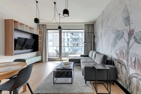 Sercem apartamentu jest przestronny salon z wygodną, rozkładaną sofą z funkcją spania, stolikiem kawowym oraz telewizorem Smart TV z dostępem do kanałów kablowych.