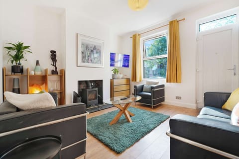 This welcoming living room features comfortable sofa seating, two armchairs, and a wall-mounted TV. With underfloor heating and a charming fireplace adding extra warmth, it’s the ultimate spot to unwind and socialise.