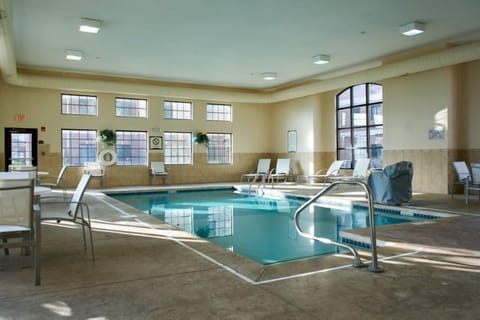 Heated indoor pool with blue tile surround — open daily 7:00 AM to 11:00 PM for guests
