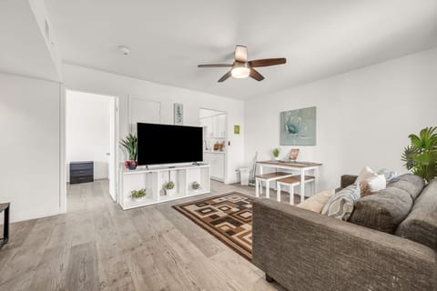 Bright open living room with smart TV, dining area, and modern decor.