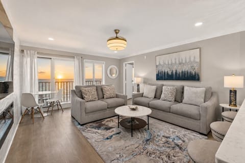 Bright, open-concept living area with comfortable seating, breakfast bar, and a fully equipped kitchen for effortless gatherings.