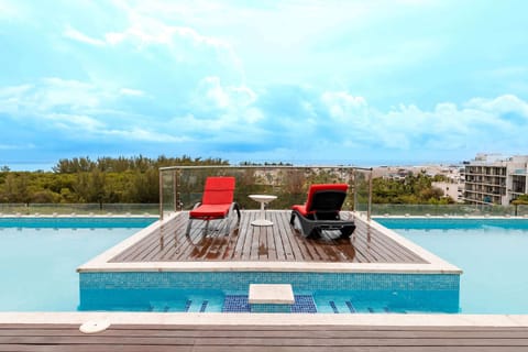 Rooftop pool and sun loungers with open views, perfect for relaxing above the city.