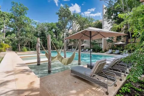 Resort pool with over-water hammocks and premium lounge chairs. A pristine tropical escape surrounded by lush native jungle, ideal for ultimate sunbathing and relaxation.