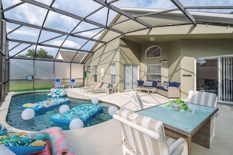 Relax by the screened pool with comfortable seating and colorful floats in a bright outdoor space.