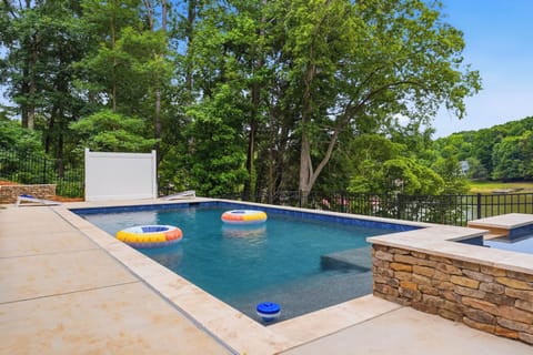 Welcome to Poolside Paradise! Dive into luxury with this stunning, pristine pool showcasing clear blue waters and integrated stone accents.